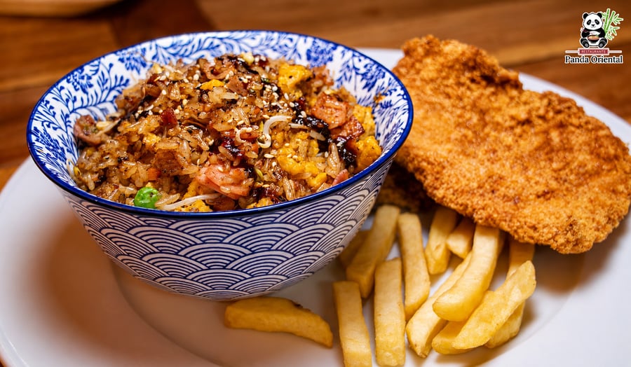 Chuleta de cerdo apanada con arroz al wok en Girardot